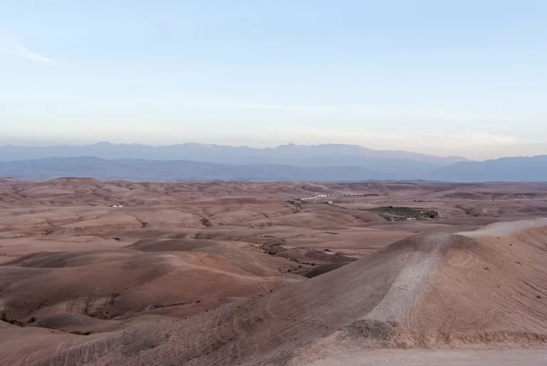 Collines du désert d’Agafay au coucher du soleil, avec l’Atlas au loin
